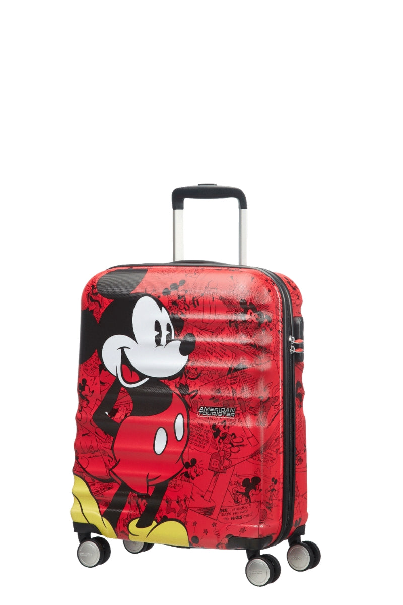 Angled front view of the American Tourister Disney Wavebreaker Mickey Comics Red cabin spinner, showing the vintage-style comic strip print and bright red shell accents. Available Online