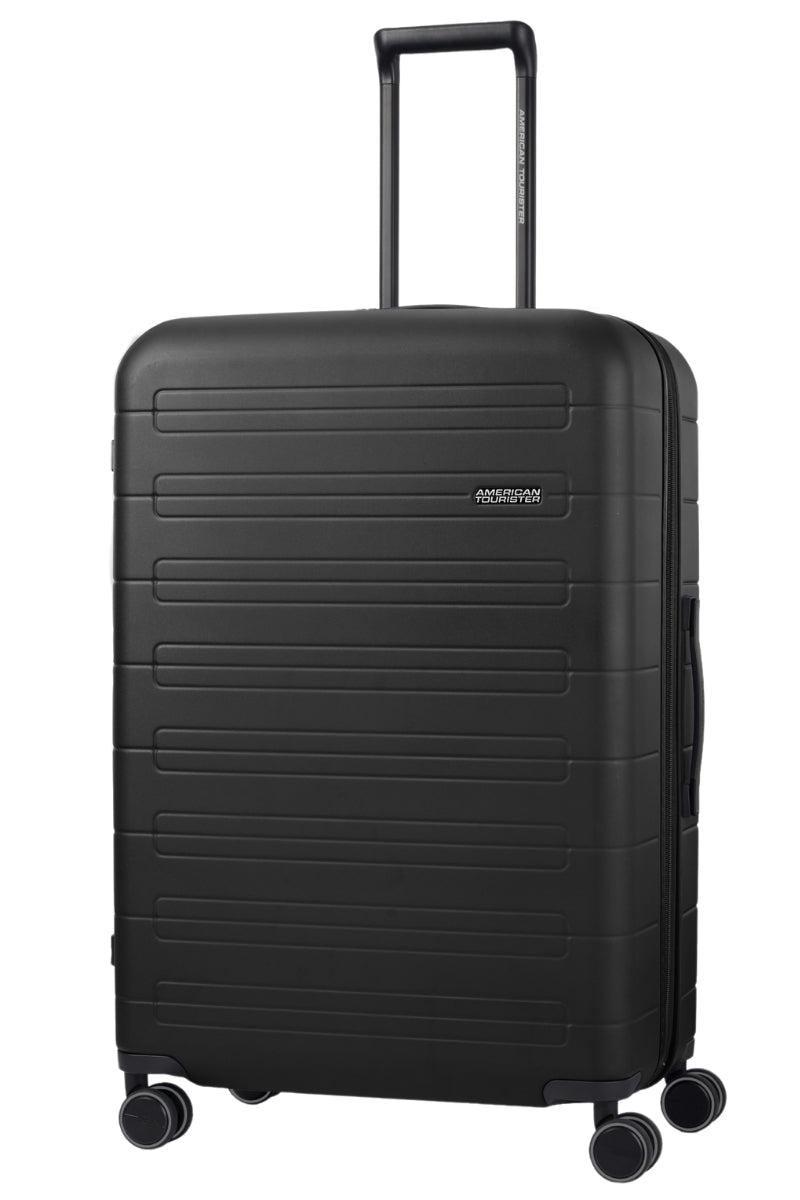 Angled view of the American Tourister Novastream Large hard suitcase Luggage in Dark Slate, with ribbed design, TSA lock, and spinner wheels. Order Online Today