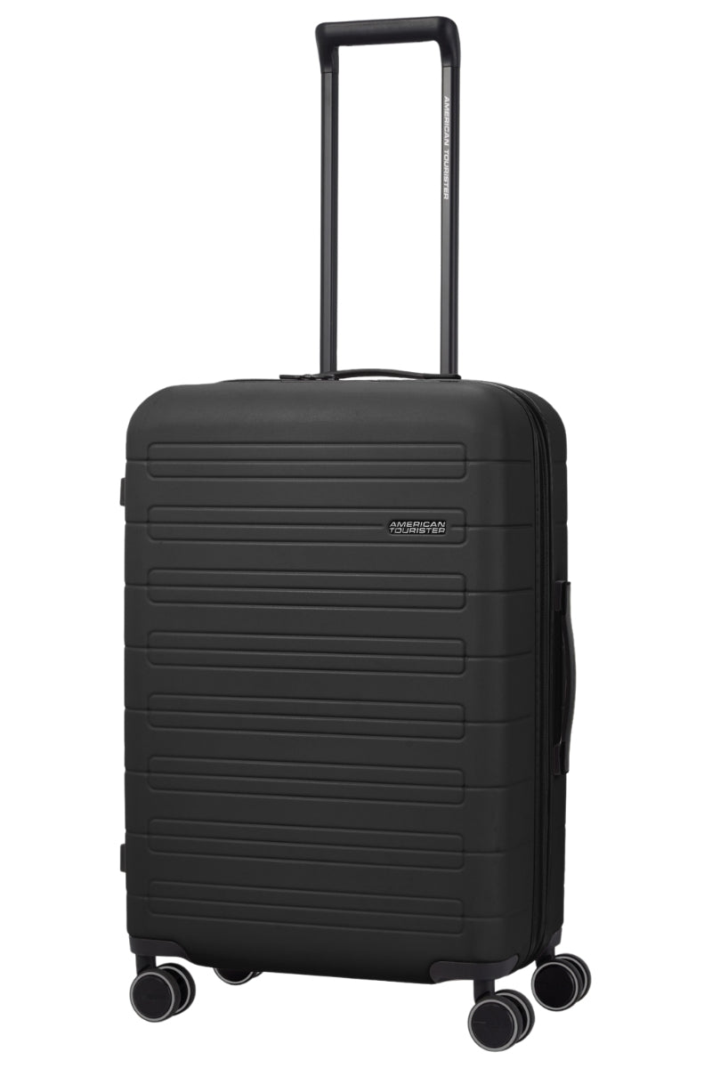 Angled view of the American Tourister Novastream Medium hard suitcase Luggage in Dark Slate, with ribbed design, TSA lock, and spinner wheels. Order Online Today