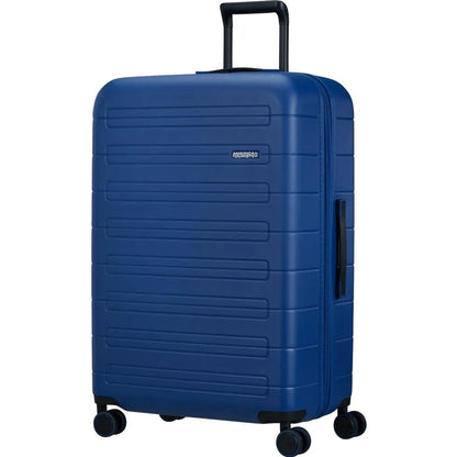 Angled view of the American Tourister Novastream hard suitcase Luggage in Navy Blue, with ribbed design, TSA lock, and spinner wheels. Order Online Today