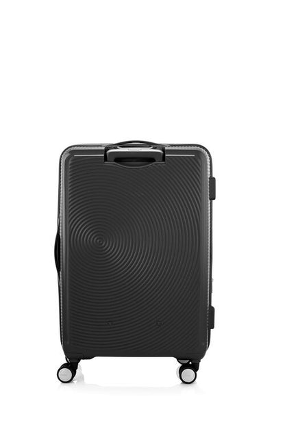 Back view of the American Tourister Curio Book Opening hard luggage spinner in Black, showcasing its iconic concentric circle "ripple" design on a durable polypropylene shell. Find Now Online