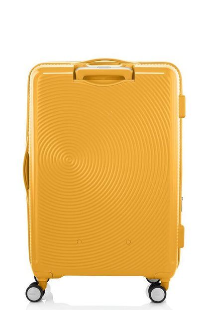 Back view of the American Tourister Curio Book Opening hard luggage spinner in Yellow, showcasing its iconic concentric circle "ripple" design on a durable polypropylene shell. Find Now Online