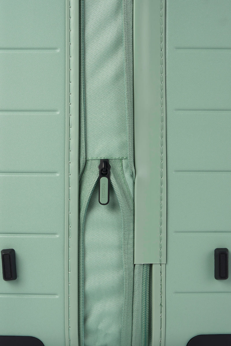 Close-up side view of the American Tourister Novastream hard suitcase Luggage in Nomad Green, with ribbed design, TSA lock, and spinner wheels. Order Online Today