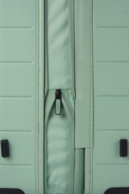 Close-up side view of the American Tourister Novastream hard suitcase Luggage in Nomad Green, with ribbed design, TSA lock, and spinner wheels. Order Online Today
