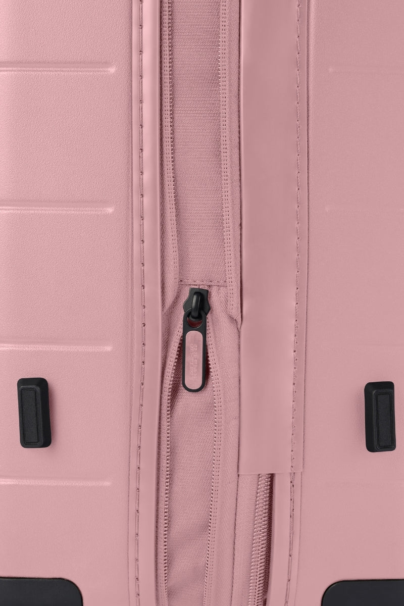 Close-up side view of the American Tourister Novastream hard suitcase Luggage in Vintage Pink, with ribbed design, TSA lock, and spinner wheels. Order Online Today