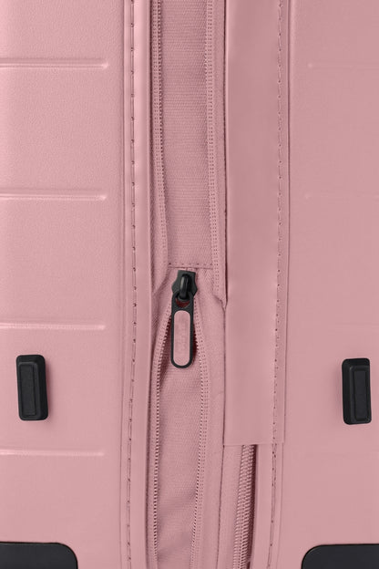 Close-up side view of the American Tourister Novastream hard suitcase Luggage in Vintage Pink, with ribbed design, TSA lock, and spinner wheels. Order Online Today