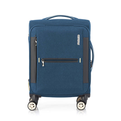 Front view of the American Tourister Droyce soft-shell spinner in Navy, featuring a modern dip-dye color gradient, grey accents, and a distinctive metal logo. Shop Now Online