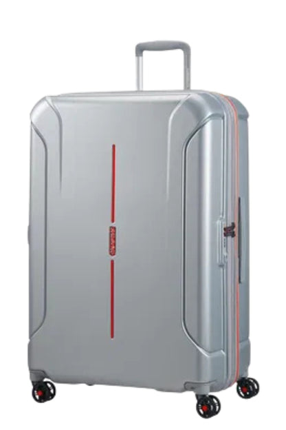 Front view of the American Tourister Technum Spinner xl in Aluminum, highlighting its modern industrial texture and bold, boxy hardshell design. Shop the Latest Online