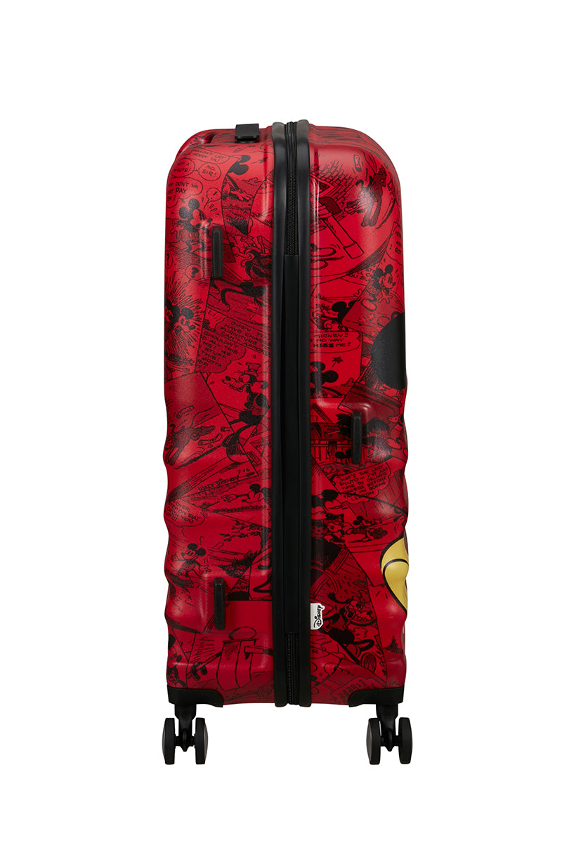 Side view of the American Tourister Disney Wavebreaker Mickey Comics Red spinner, showing the vintage-style comic strip print and bright red shell accents. Available Online