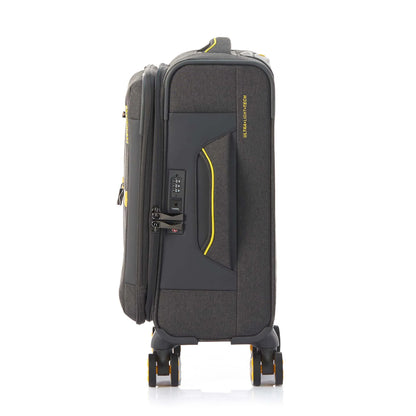Side view of the American Tourister Droyce soft-shell spinner in Grey, featuring a modern dip-dye color gradient, yellow accents, and a distinctive metal logo. Shop Now Online